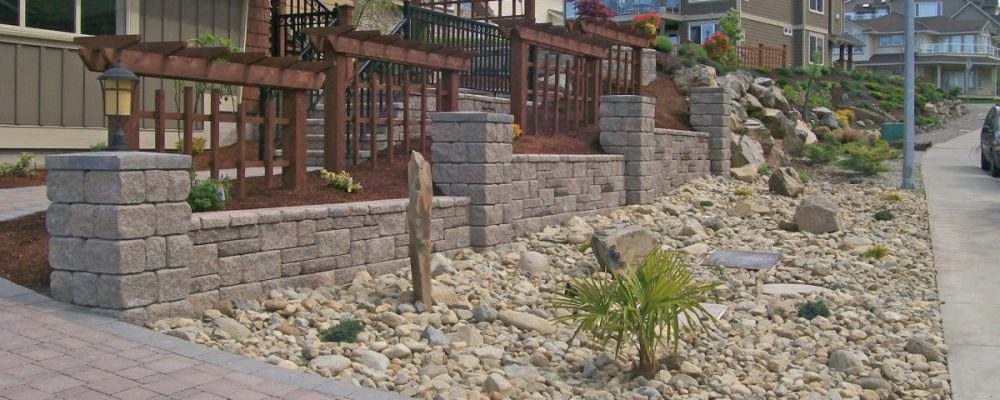 allan block wall fence with rock garden